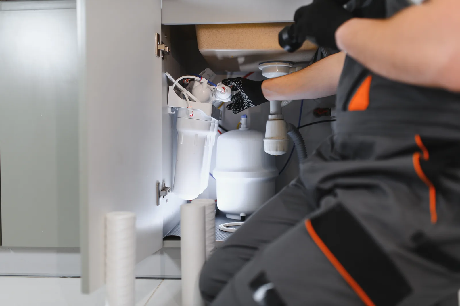 Technician replacing kitchen filter cartridges on a maintenance visit